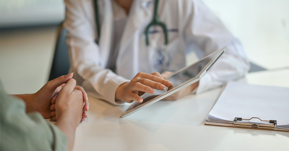 Doctor showing a patient some information on a digital tablet